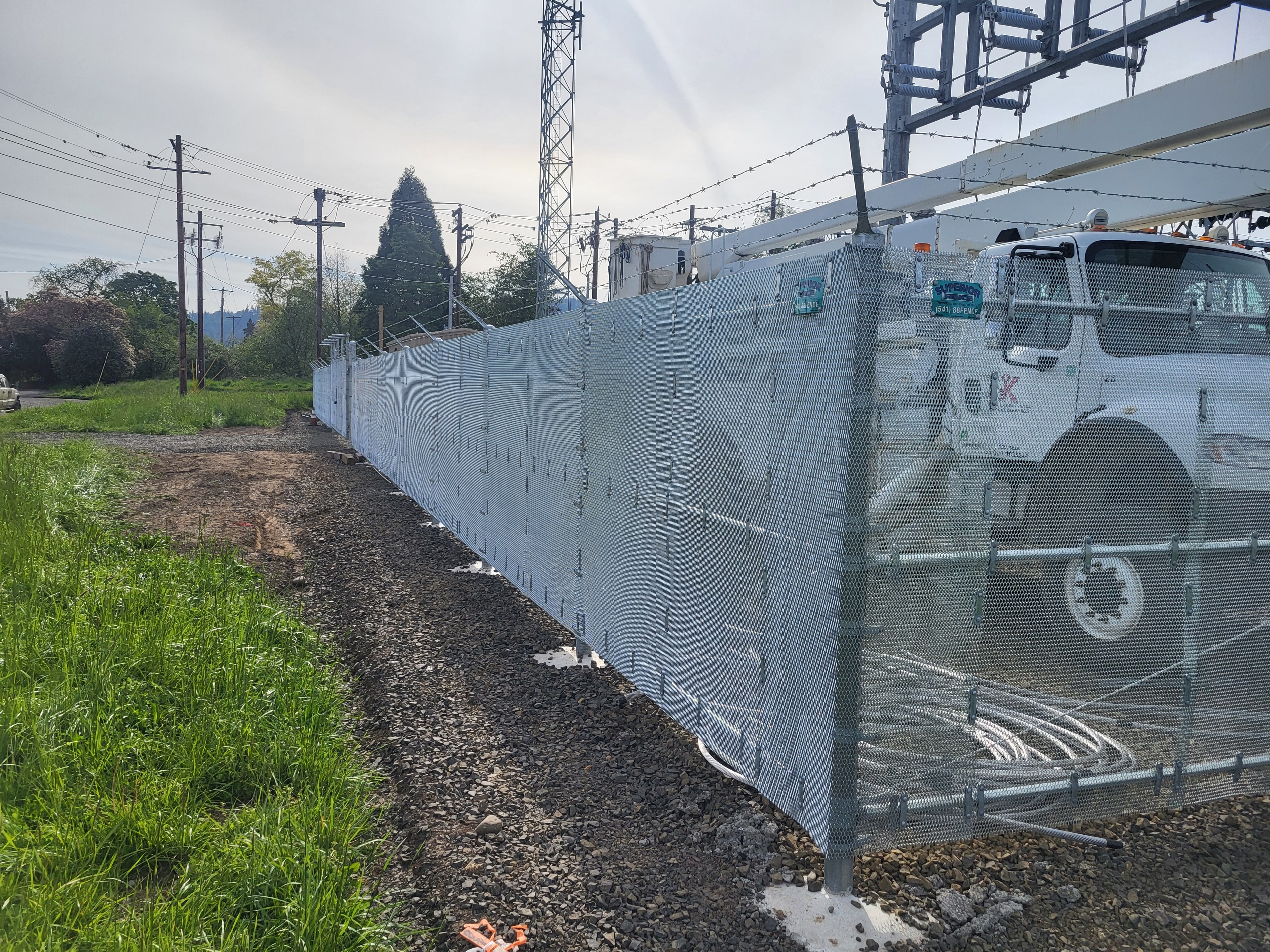 Industrial chain link fence with privacy screening installed at a utility substation — Southern Oregon