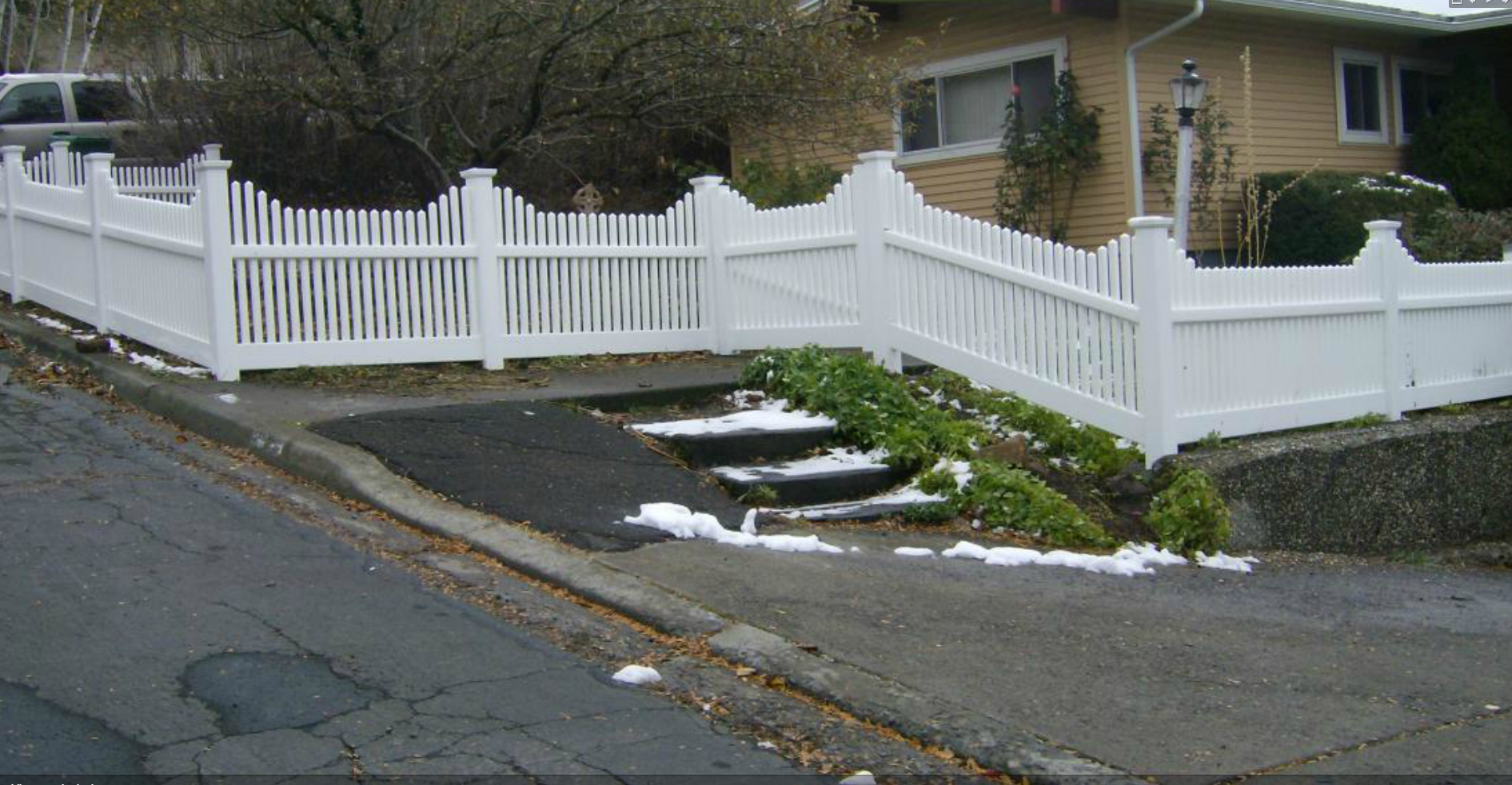 White vinyl picket fence with concave top installed along a residential front yard — Superior Fence, Klamath Falls OR
