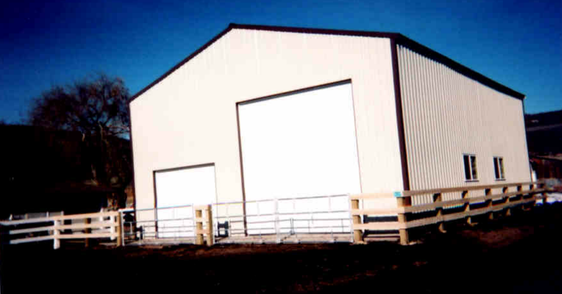 Wood rail fence surrounding a barn and agricultural property